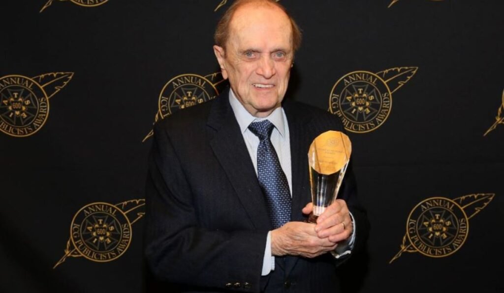 Bob Newhart holds up award